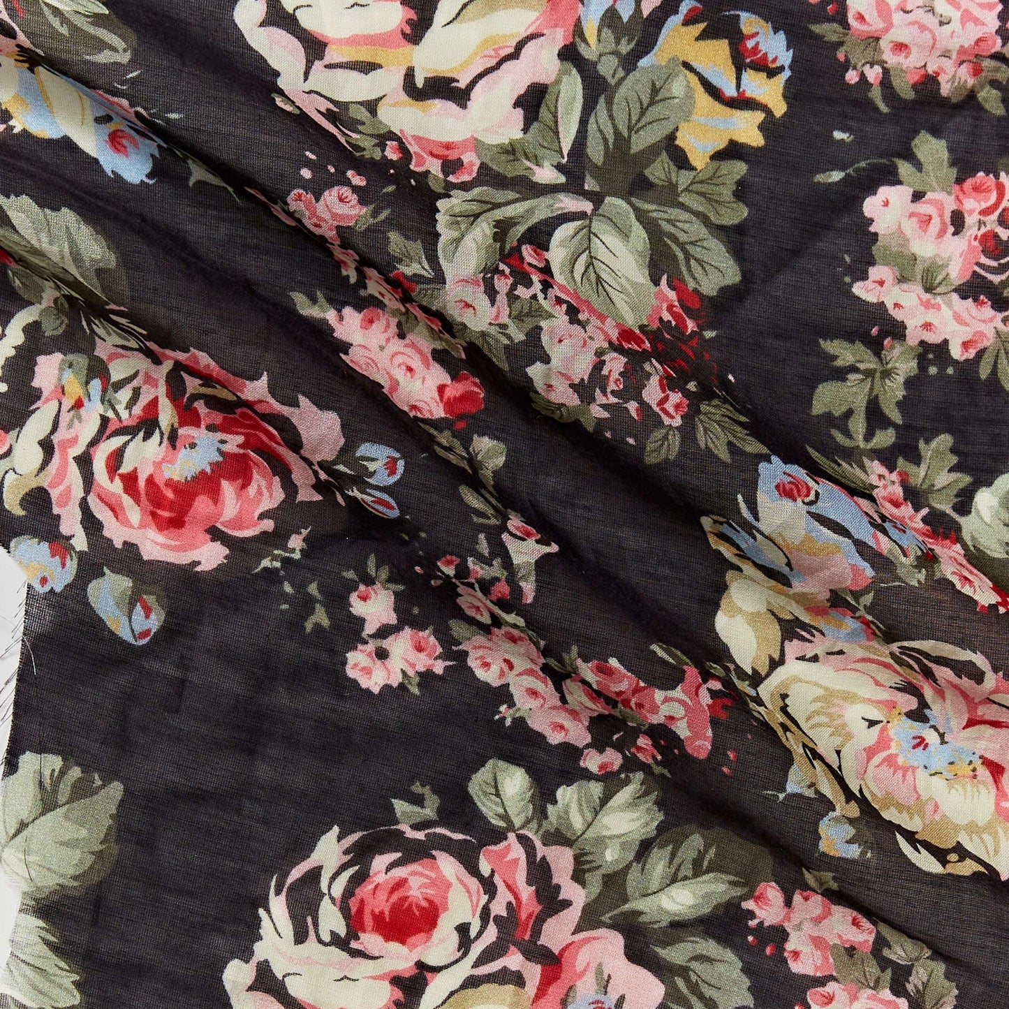 Showing cabbage a rose floral print on black base silk blended with cotton featuring good drape