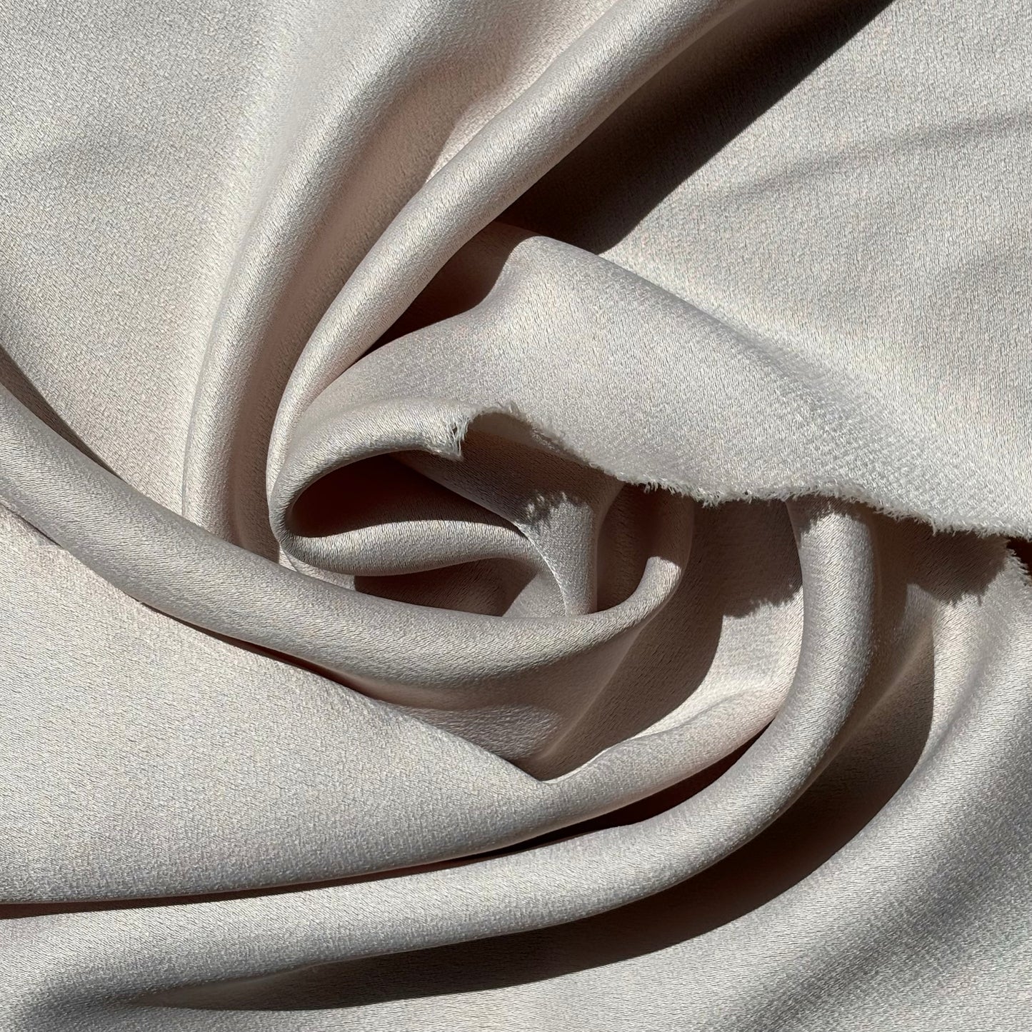 celebrity displaying the latte colored version of a polyester microfiber featuring a double sided matte face & satin back crepe with fluid drape