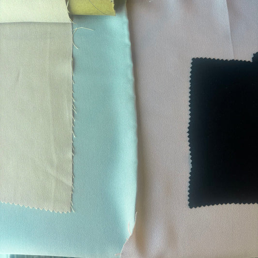 Presenting the Columbia Fabric swatches corn, mint, rose and black on a flat surface