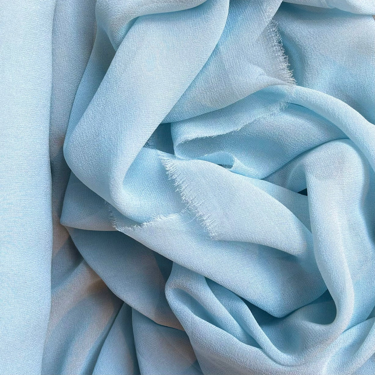 silk georgette presenting the blue color version of a Lightweight sheer floaty pure silk with excellent drape great for layering and gathering