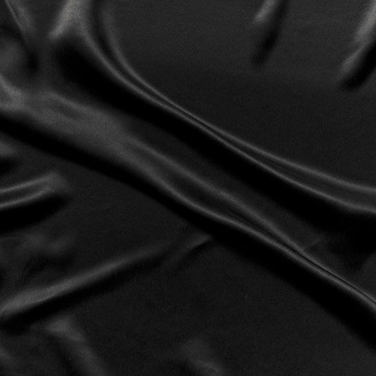 supremo showing the black color version of a soft sand washed delustered pure silk with fluid drape