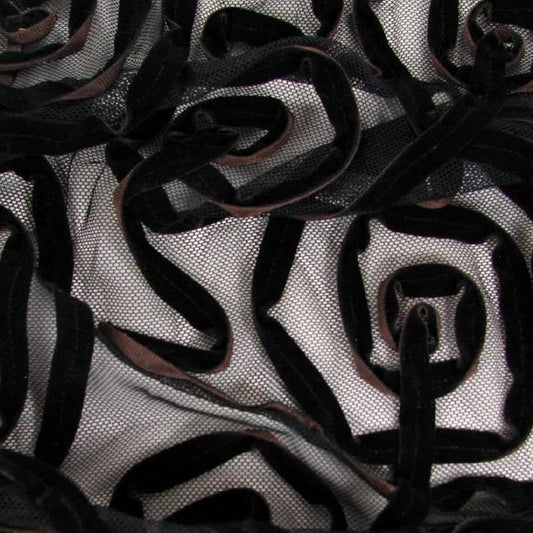 alannah presenting the brown color version of a nylon and polyester velvet ribbon squiggles on sheer mesh base in closeup