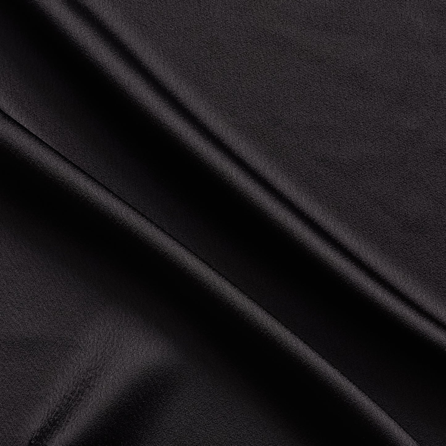 celebrity displaying the black colored version of a polyester microfiber satin back crepe with fluid drape