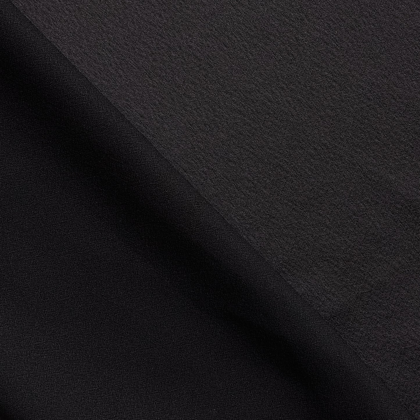 celebrity displaying the black colored version of a polyester microfiber satin back crepe with fluid drape