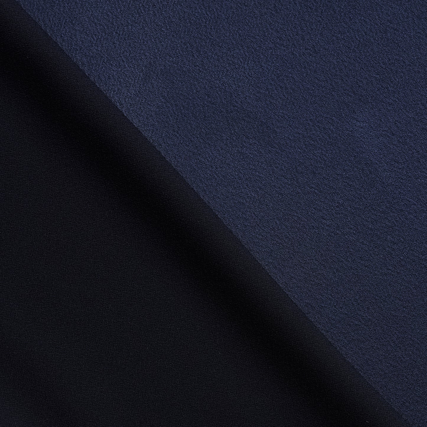 celebrity displaying the dark navy colored version of a polyester microfiber satin back crepe with fluid drape