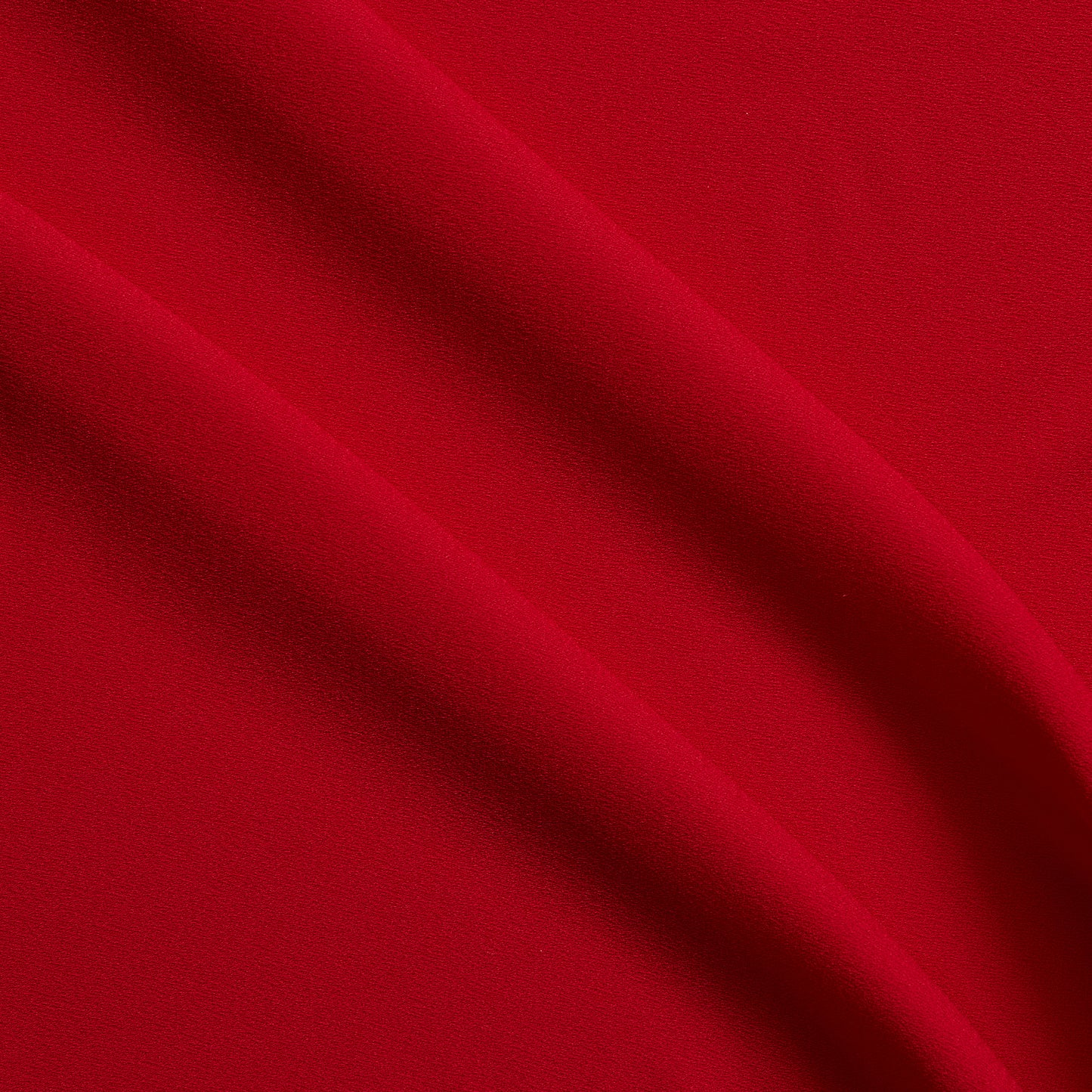 celebrity displaying the red colored version of a polyester microfiber double sided matte face & satin back crepe with fluid drape