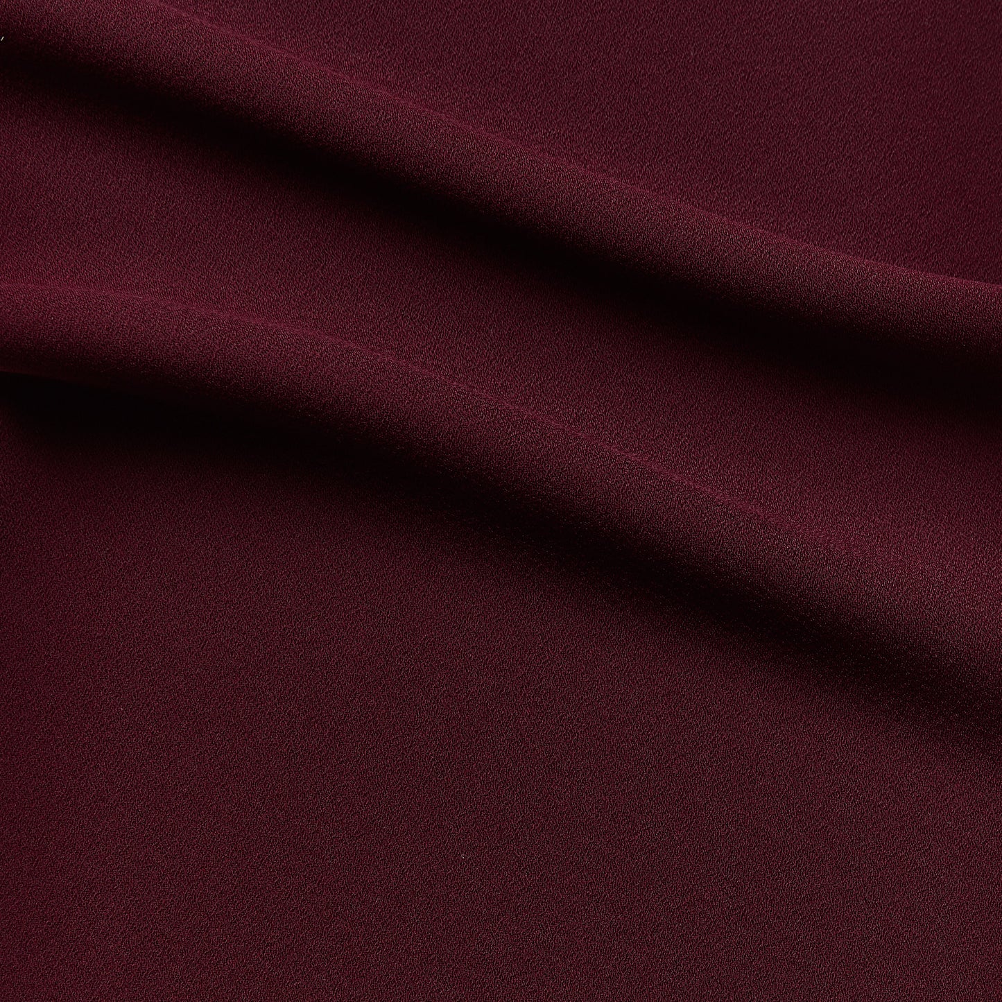 celebrity displaying the ruby colored version of a polyester microfiber back side with fluid drape