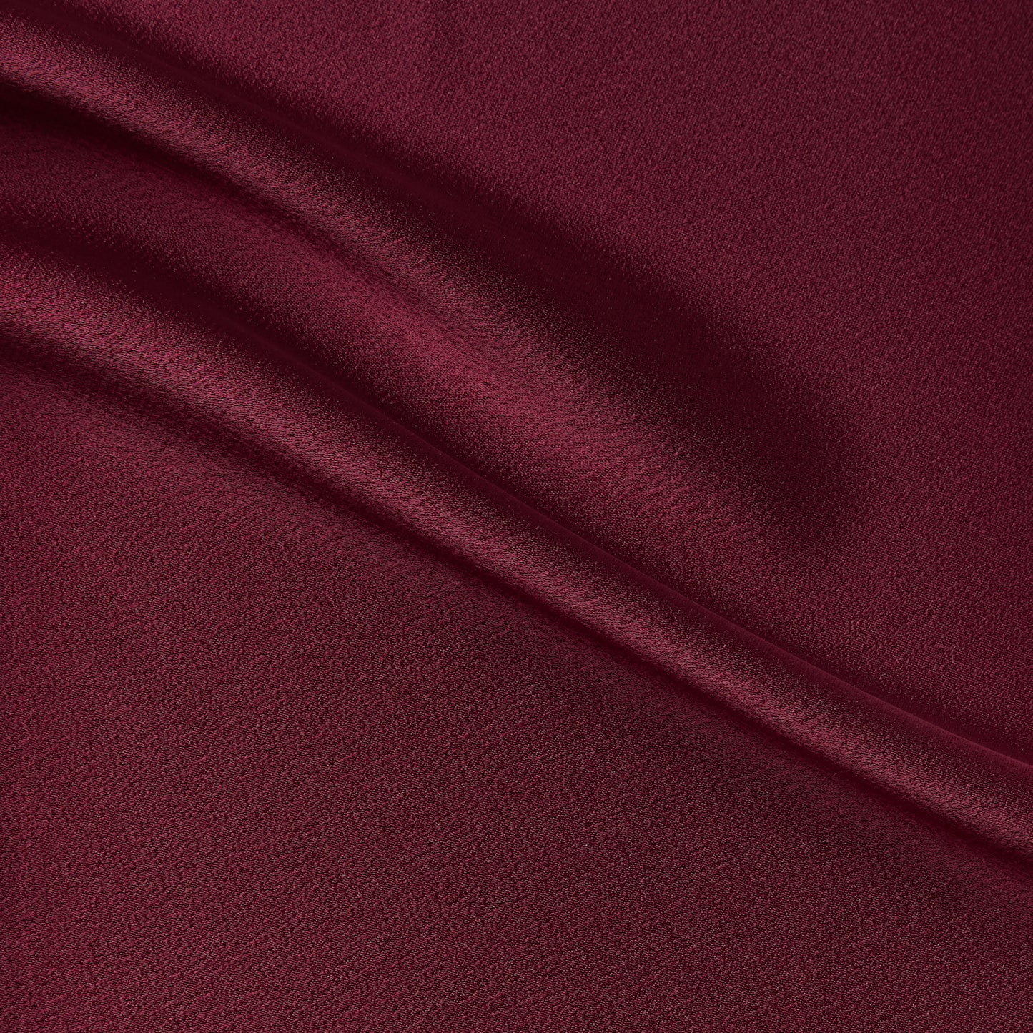 celebrity displaying the ruby colored version of a polyester microfiber double sided matte face & satin back crepe with fluid drape