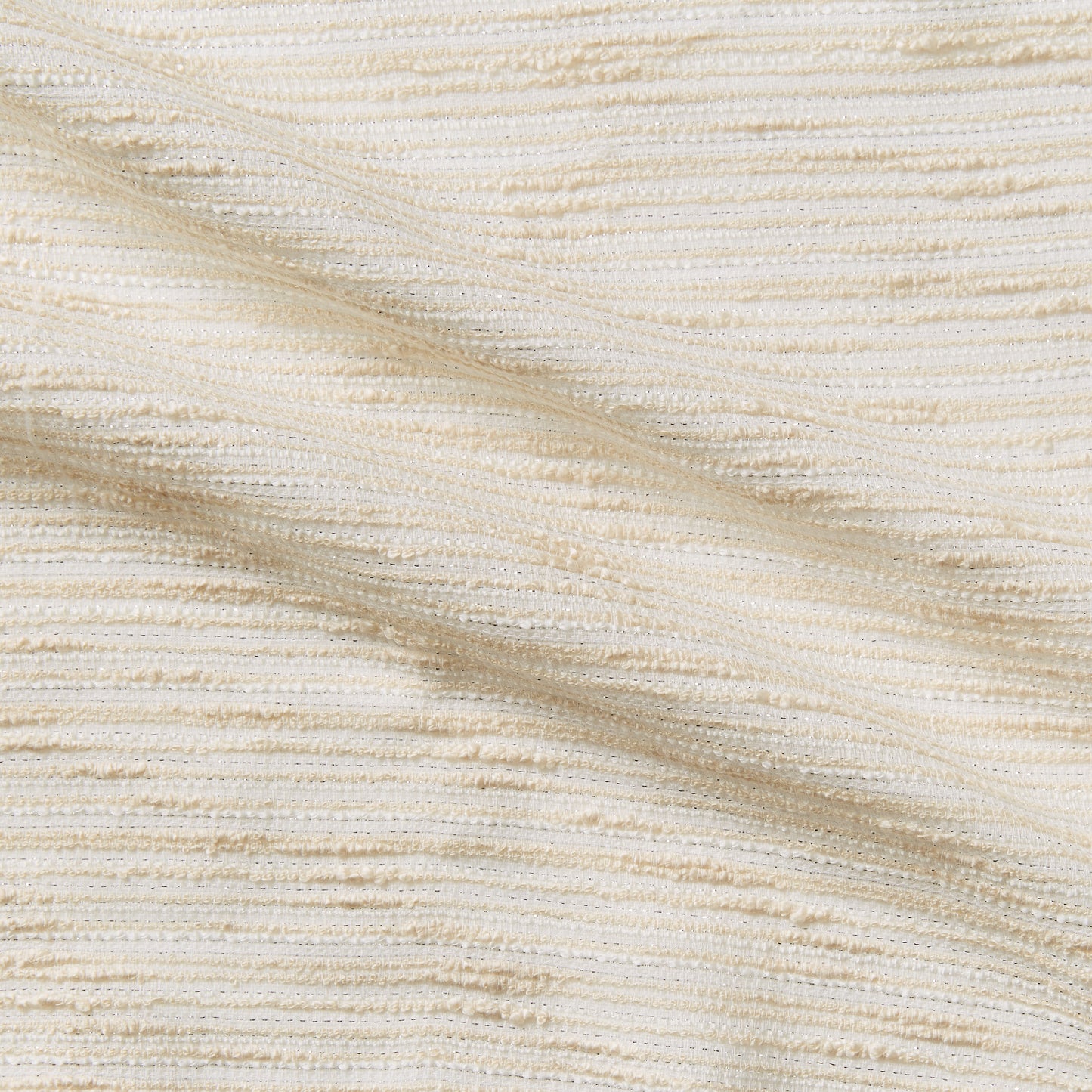 coco displaying the cream color version of a polyester cotton blend bouclé fabric with lurex thread
