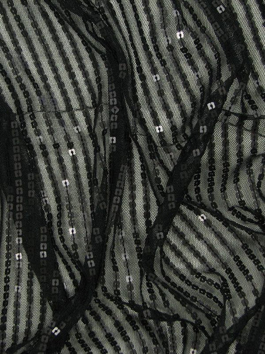 Presenting camelot with stripes of black sequins on black colored mesh base polyester and nylon blend with good drape shown in folds