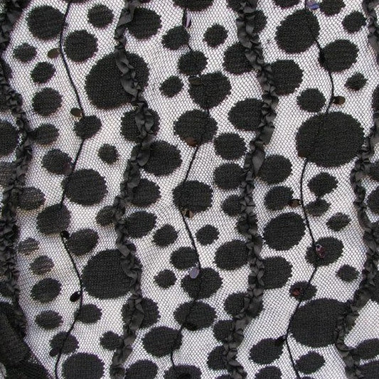 Dazzle presenting a fabric featuring black spots and ribbon embroidered on black colored mesh as a polyester and nylon blend closeup