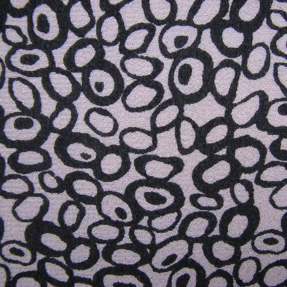Displaying Hoops a Black colored fabric with a timeless Abstract black and white print on heavy Pure Silk georgette in closeup