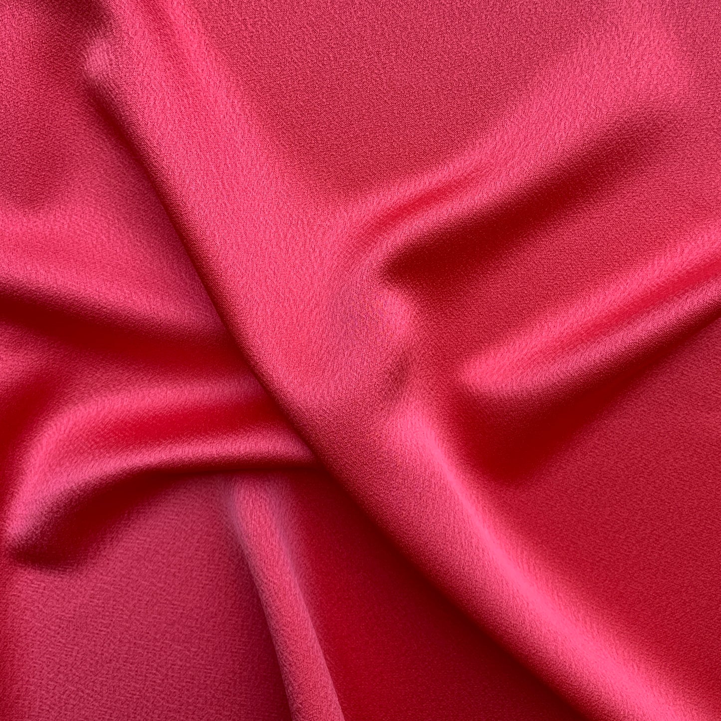 Celebrity displaying the Scarlet Color Version of a satin backed crepe polyester microfiber with fluid drape