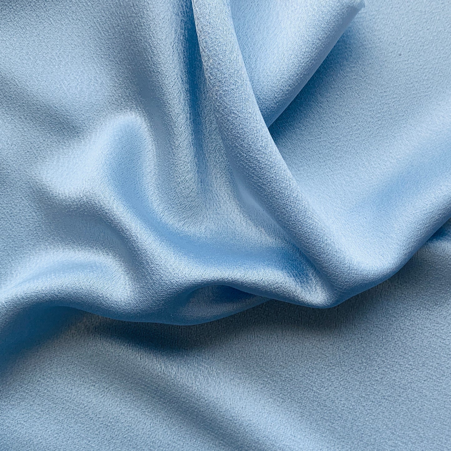 Celebrity displaying the Blue Color Version of a satin backed crepe polyester microfiber with fluid drape