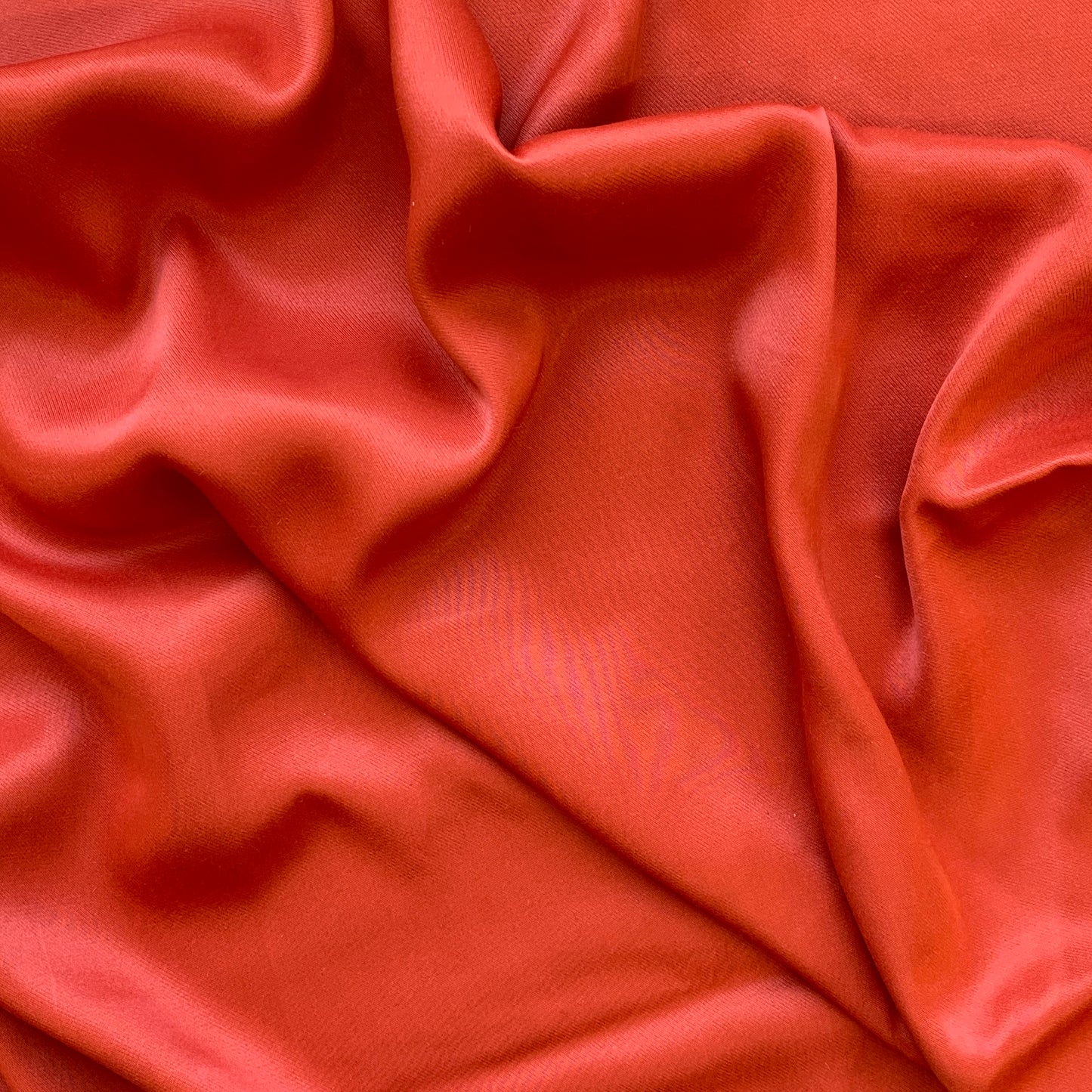 sakura presenting the lava color version of a satin bamboo and viscose blend with both satin and matte faces featuring fluid drape