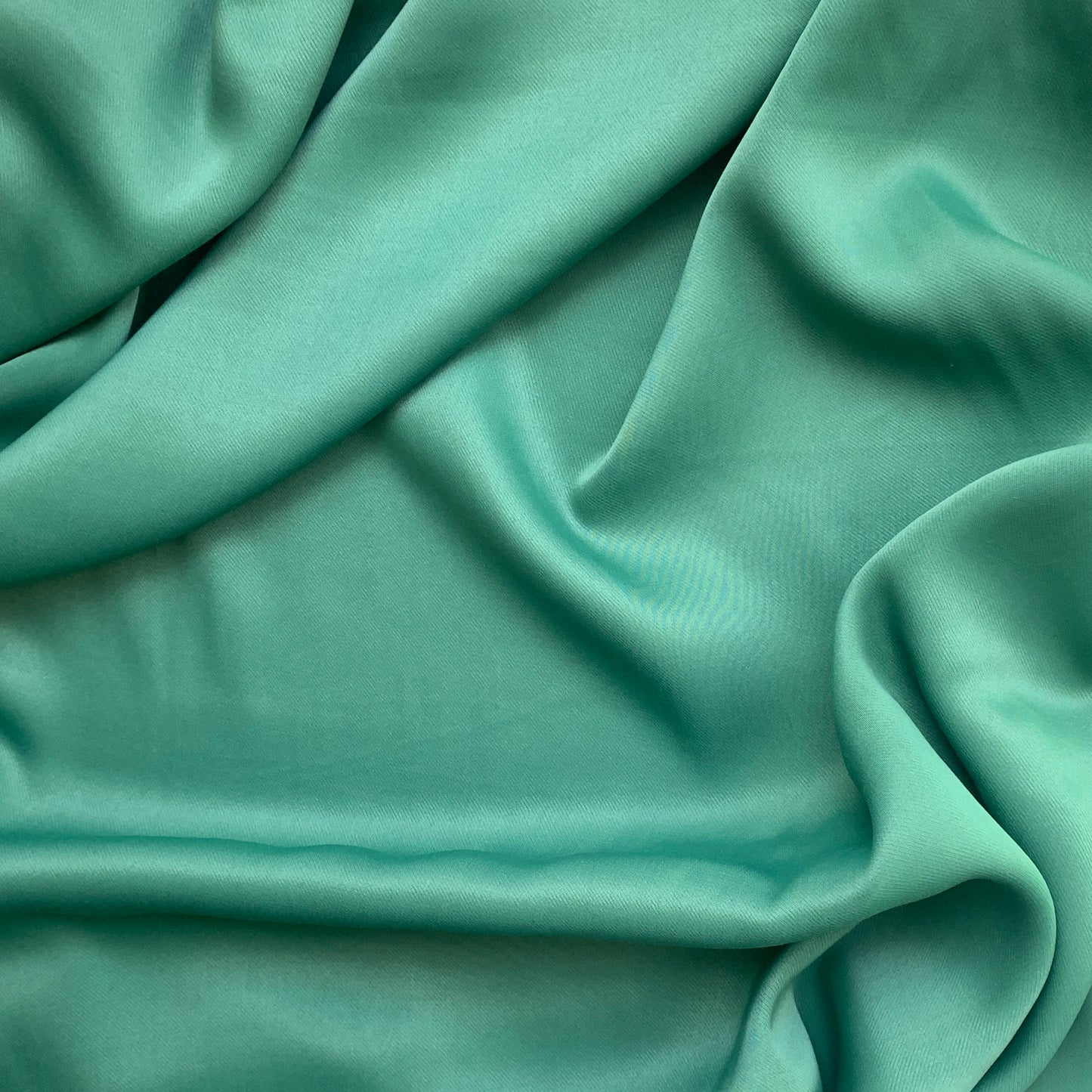 sakura presenting the sage color version of a satin bamboo and viscose blend with both satin and matte faces featuring fluid drape