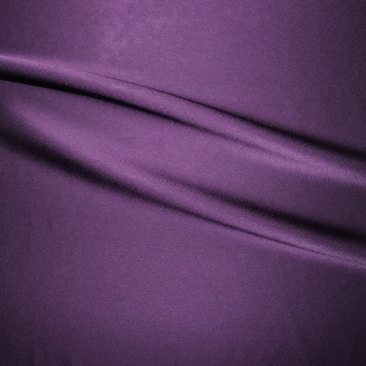 celebrity displaying the teal colored version of a polyester microfiber double sided  matte face & satin back crepe with fluid drape