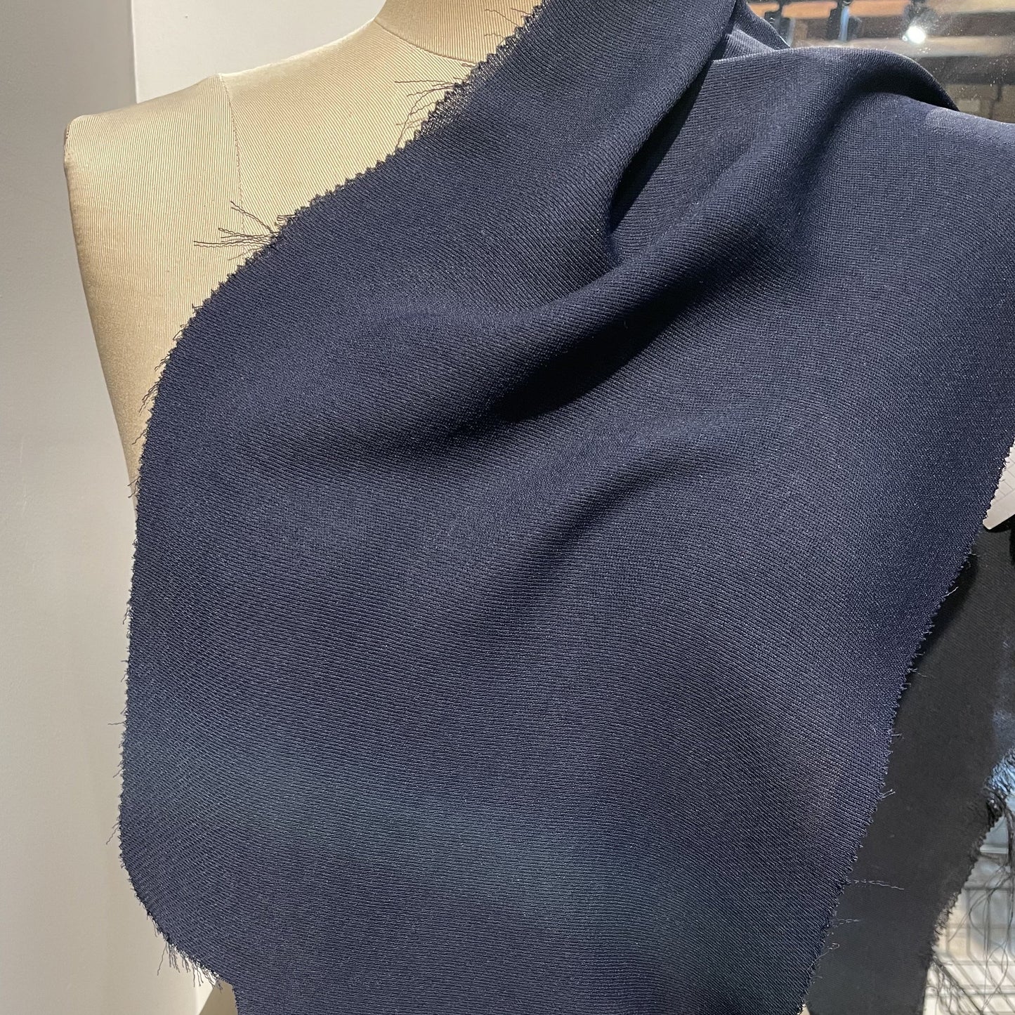 ultima presenting the navy color version of a polyester and acetate blend semi sheer mid weight textured fabric with fluid drape