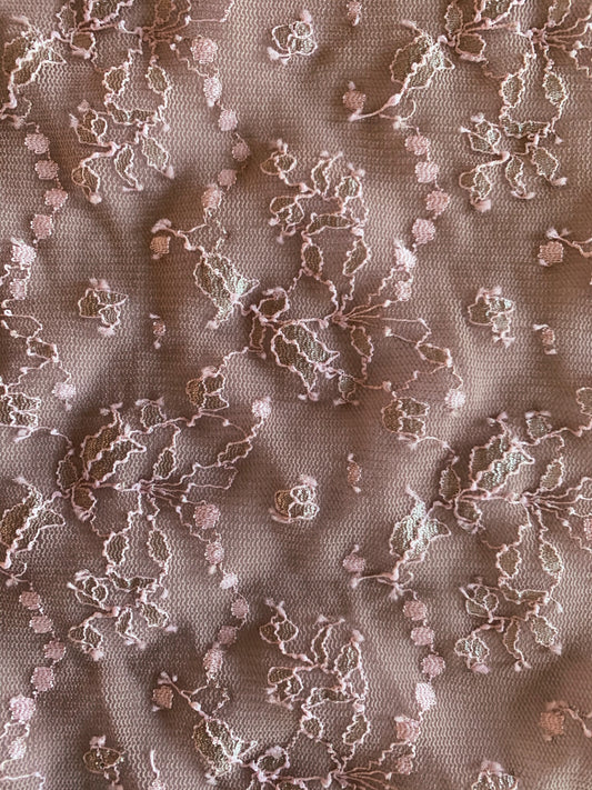cindy presenting the coffee color version of a floral themed lurex threaded delicate embroidery on dusty lace composed of nylon, polyester with spandex with good drape