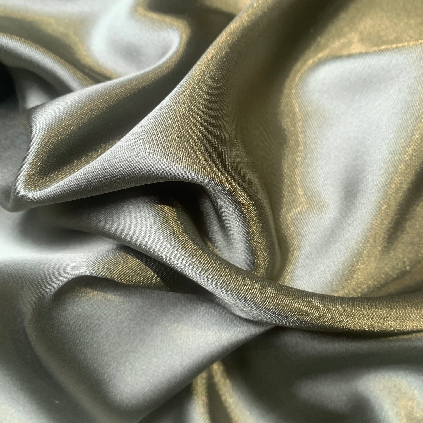 lola presenting the olive color version of a stretch light weight soft satin polyester with spandex