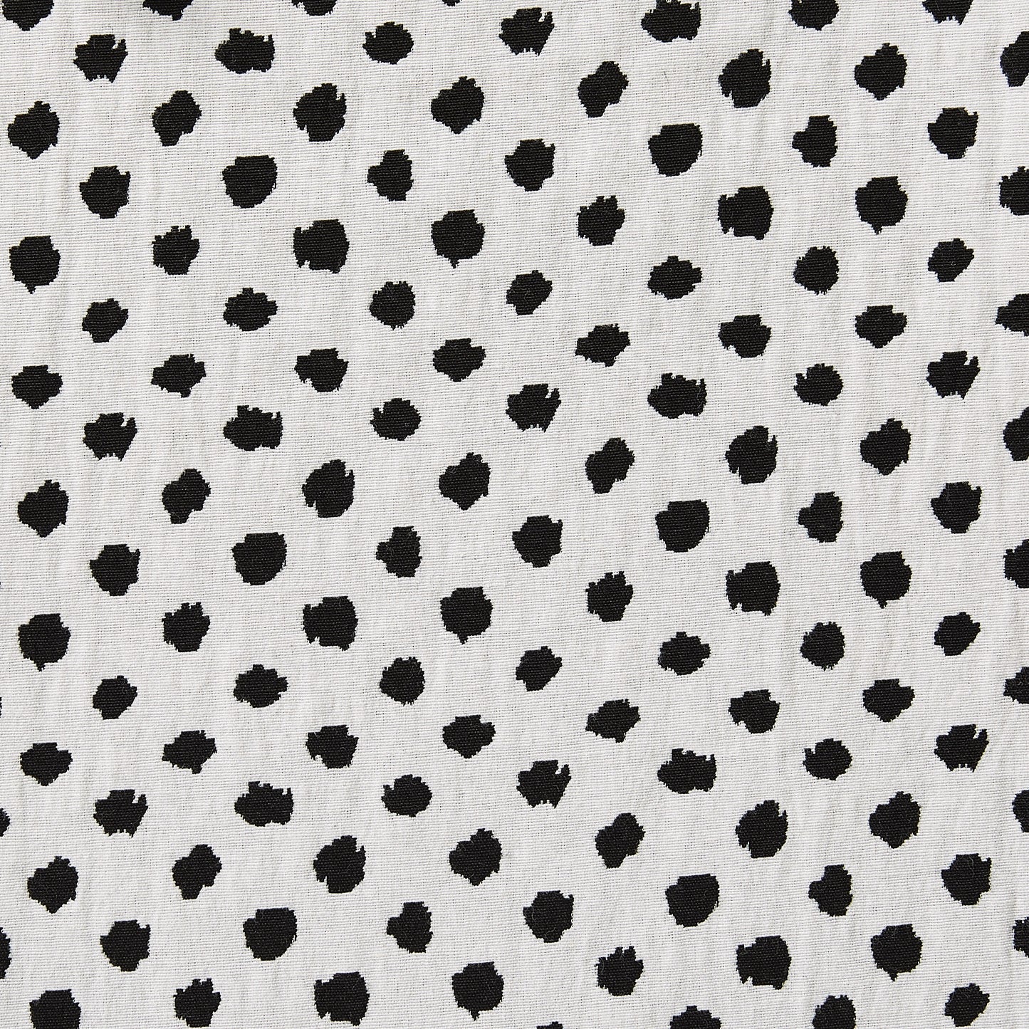 meteor presenting the reverse stretchable, reversible, cotton poly with spandex blend featuring a dobby weave with spotty blotches showing reverse side of black on white