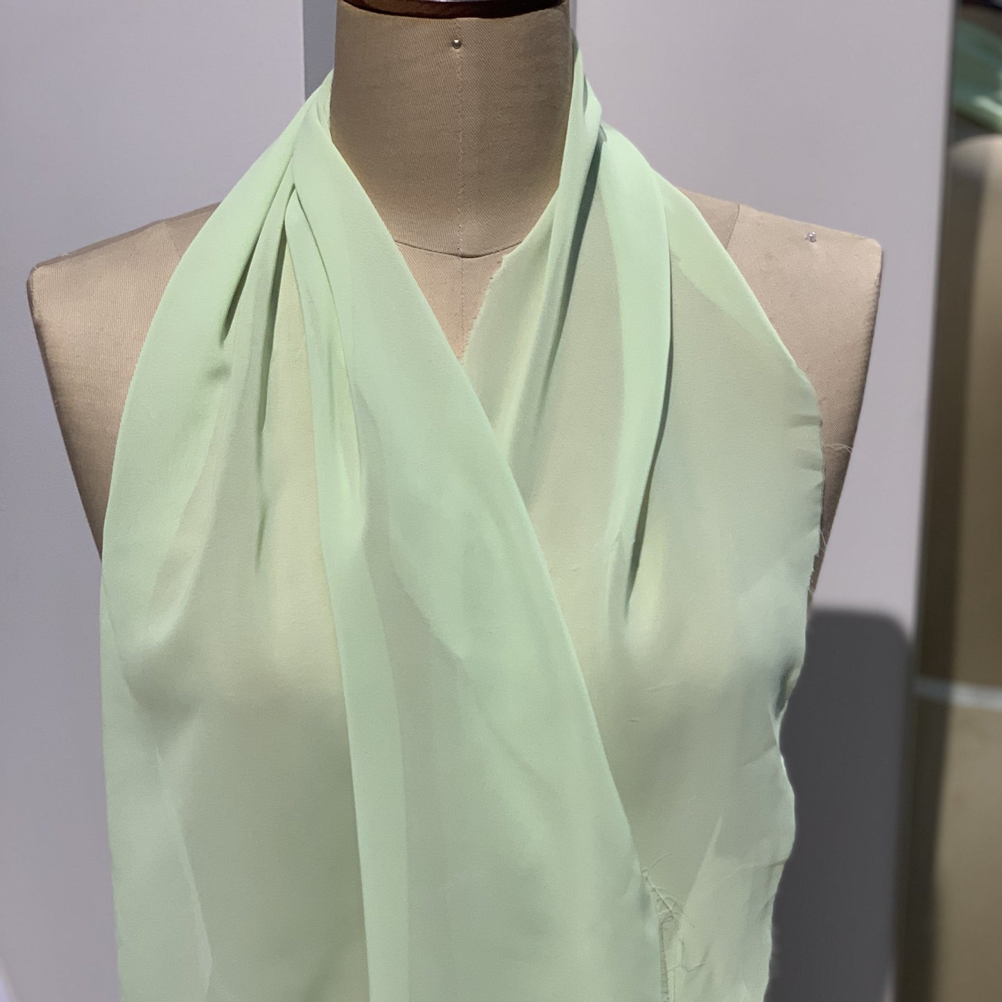 microgette presenting the apple color version of a sheer soft plain weave Polyester microfibre with matte face and good drape draped on a mannequin
