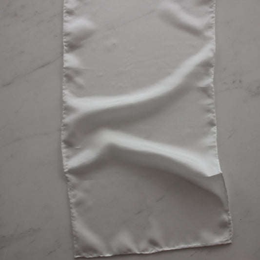 Presenting pajeant scarf featuring a natural colored soft feather weight pure silk 28cm x 160cm with rolled edge and floaty fluid drape