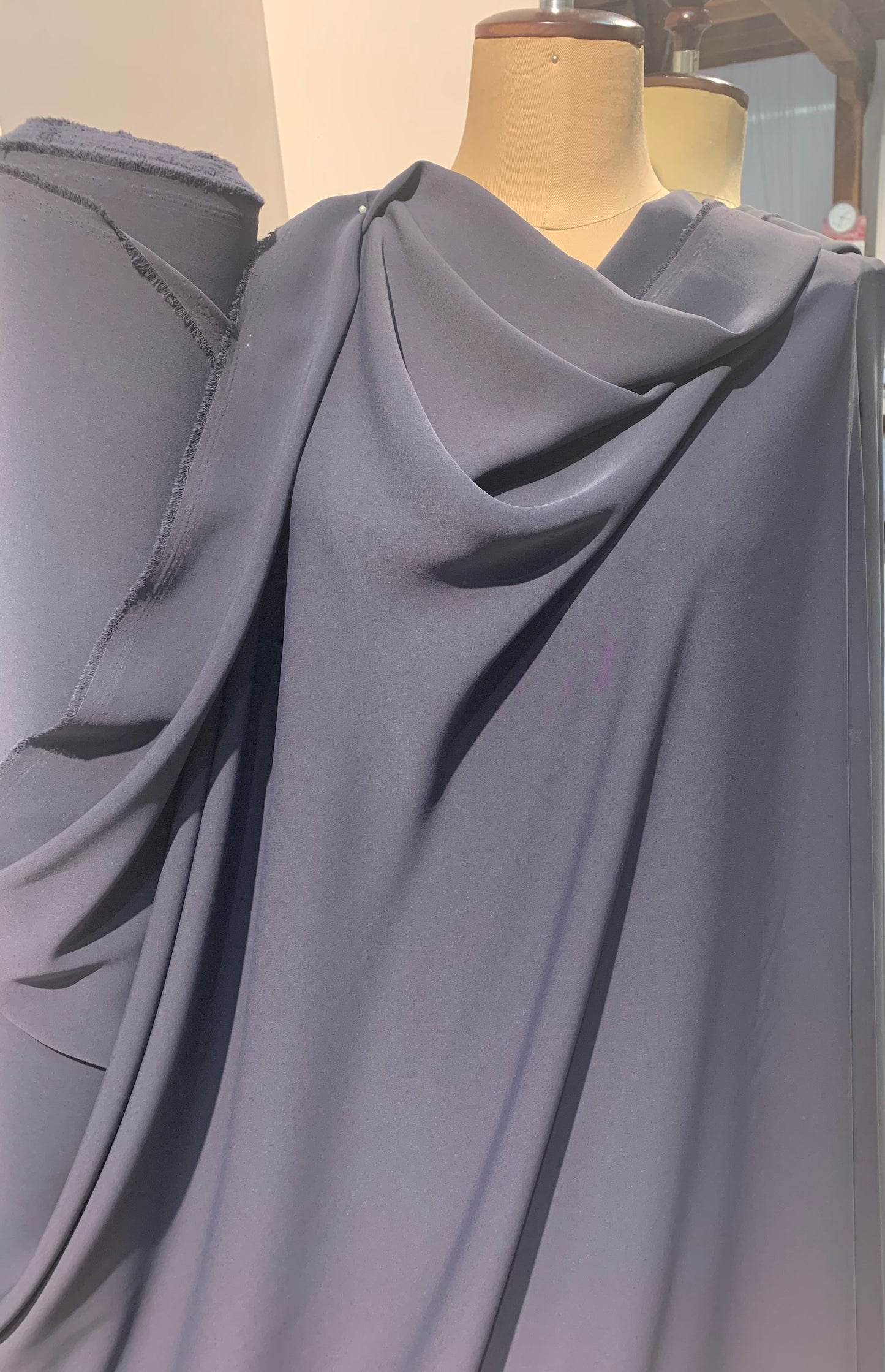 sensation presenting the charcoal color version of a medium weight pure polyester draped and fluid drape