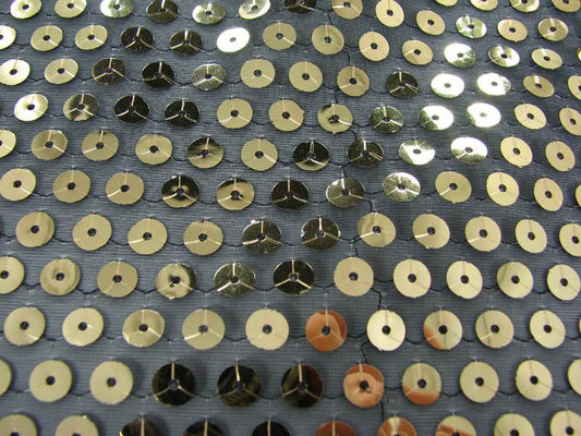 Showing sequin Georgette with a closeup of the Gold colored sequins on sheer georgette polyester black mesh