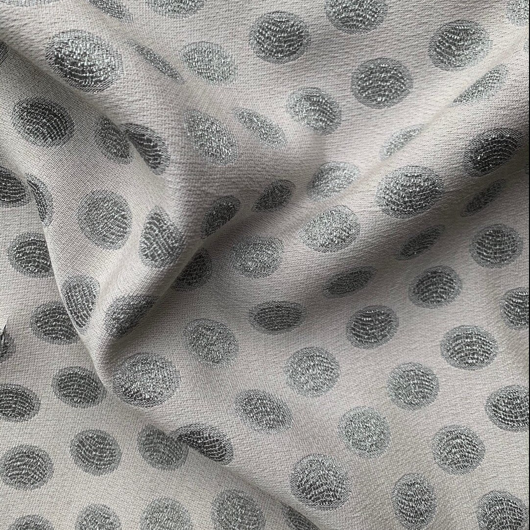 scramble presenting the silver color version of a medium weight polyester blend featuring metallic spots with lurex thread and good drape