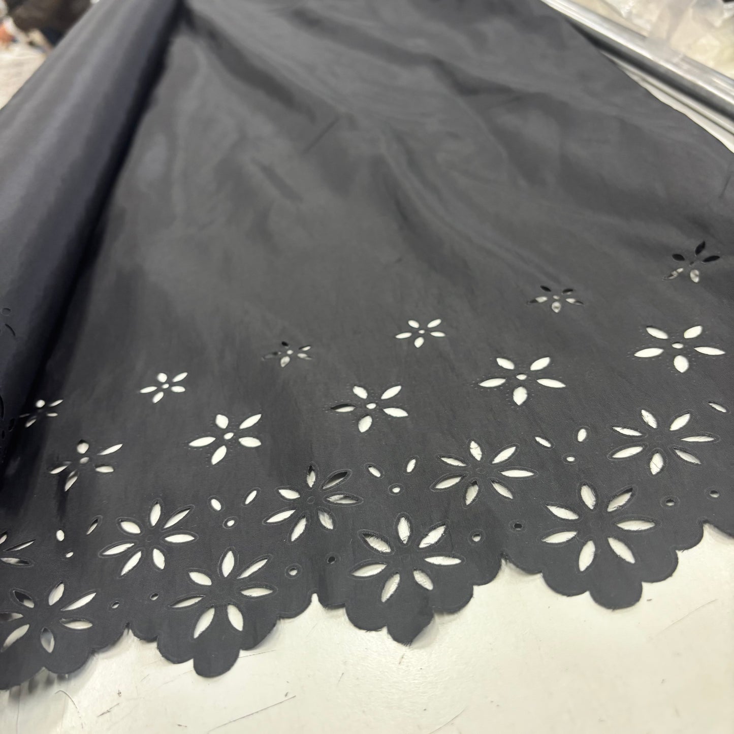 Showing Blowout Black fabric with white floral cut-out patterns on a white floor.