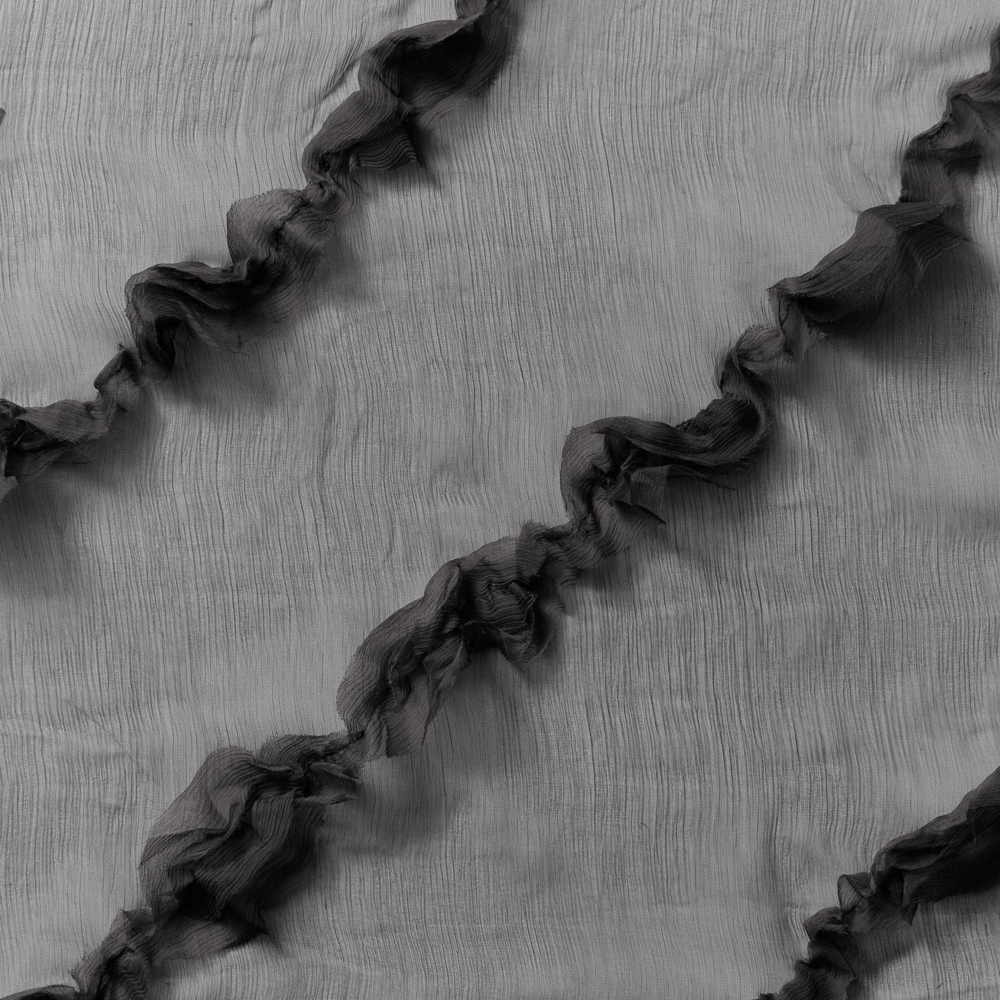 Displaying presenting black colored crinkle light weight sheer pure silk chiffon with diagonal ruffle flounce 