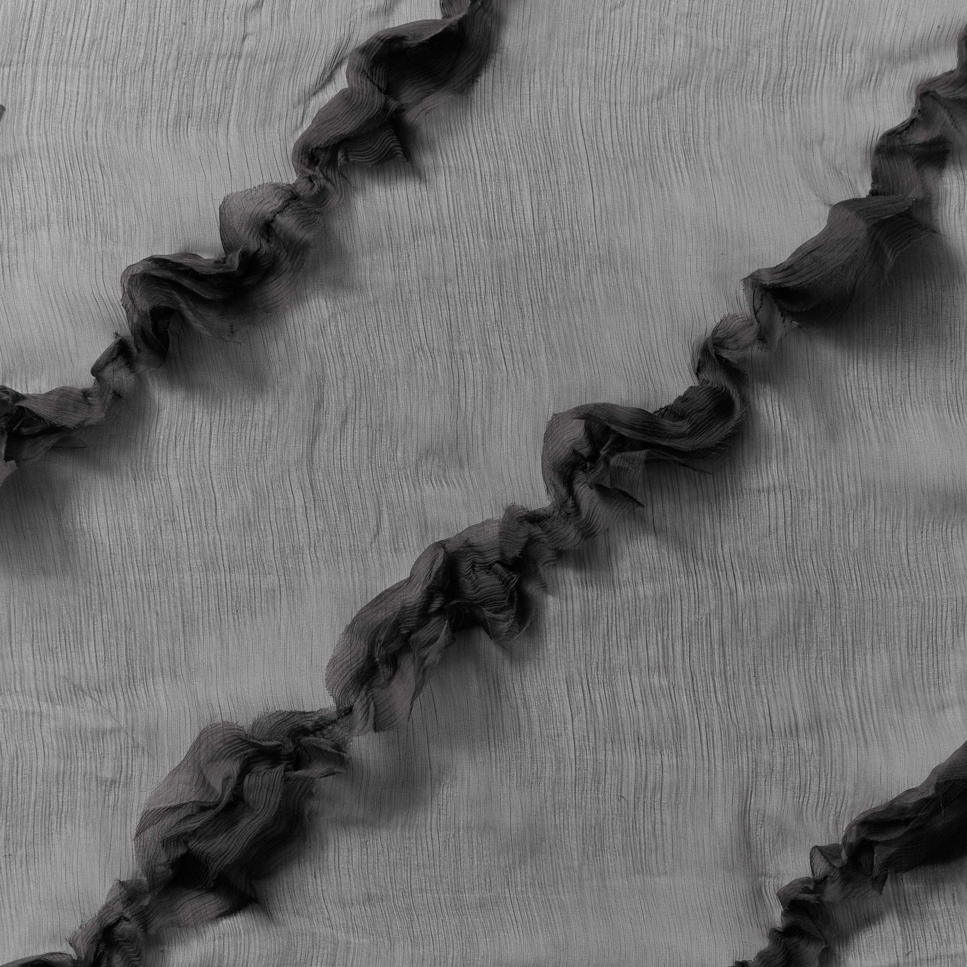 Displaying presenting black colored crinkle light weight sheer pure silk chiffon with diagonal ruffle flounce 