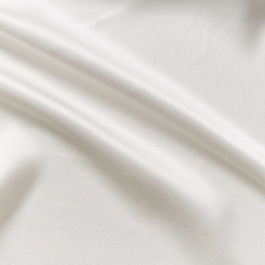 Presenting charmeuse a natural colored pure light weight silk with satin lustre and fluid drape featuring a wide width