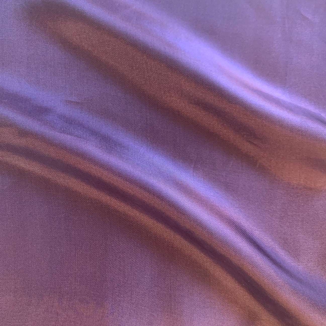 saga showing the aubergine color version of a pure rayon Fine twill satin with fluid drape