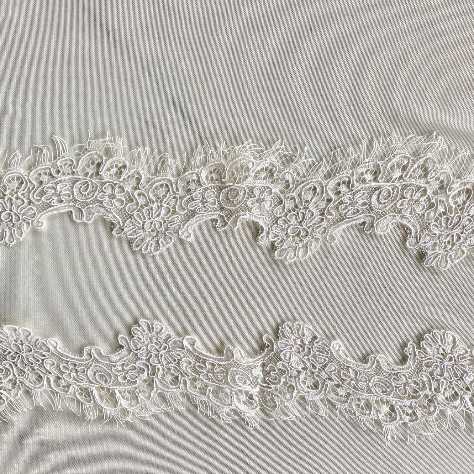 Presenting ingrid an ivory colored Scalloped rayon and nylon lace with corded embroidery and eyelash on trim