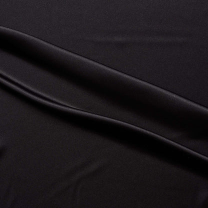 lola presenting the black color version of a stretch light weight soft satin polyester with spandex