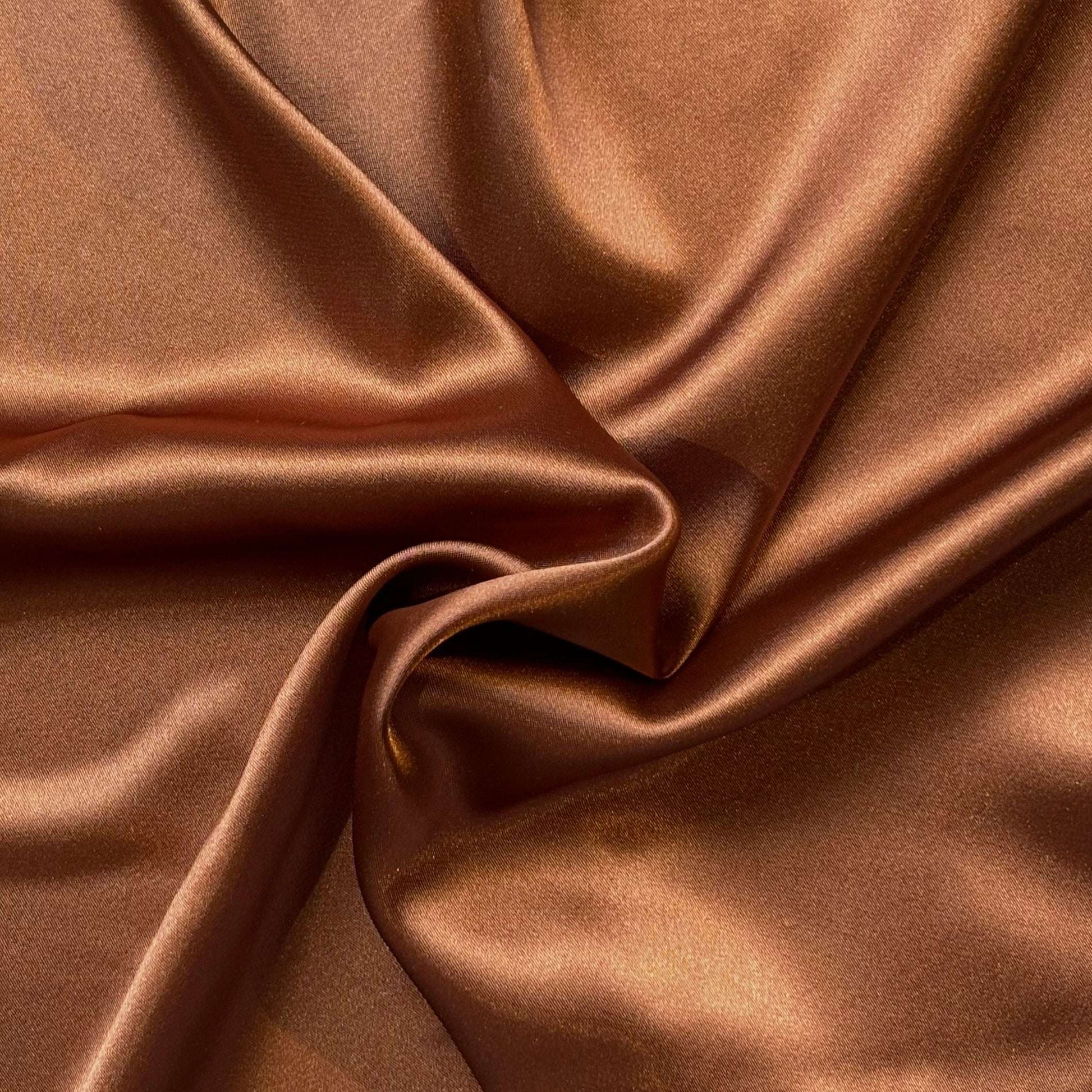 lola presenting the bronze color version of a stretch light weight soft satin polyester with spandex
