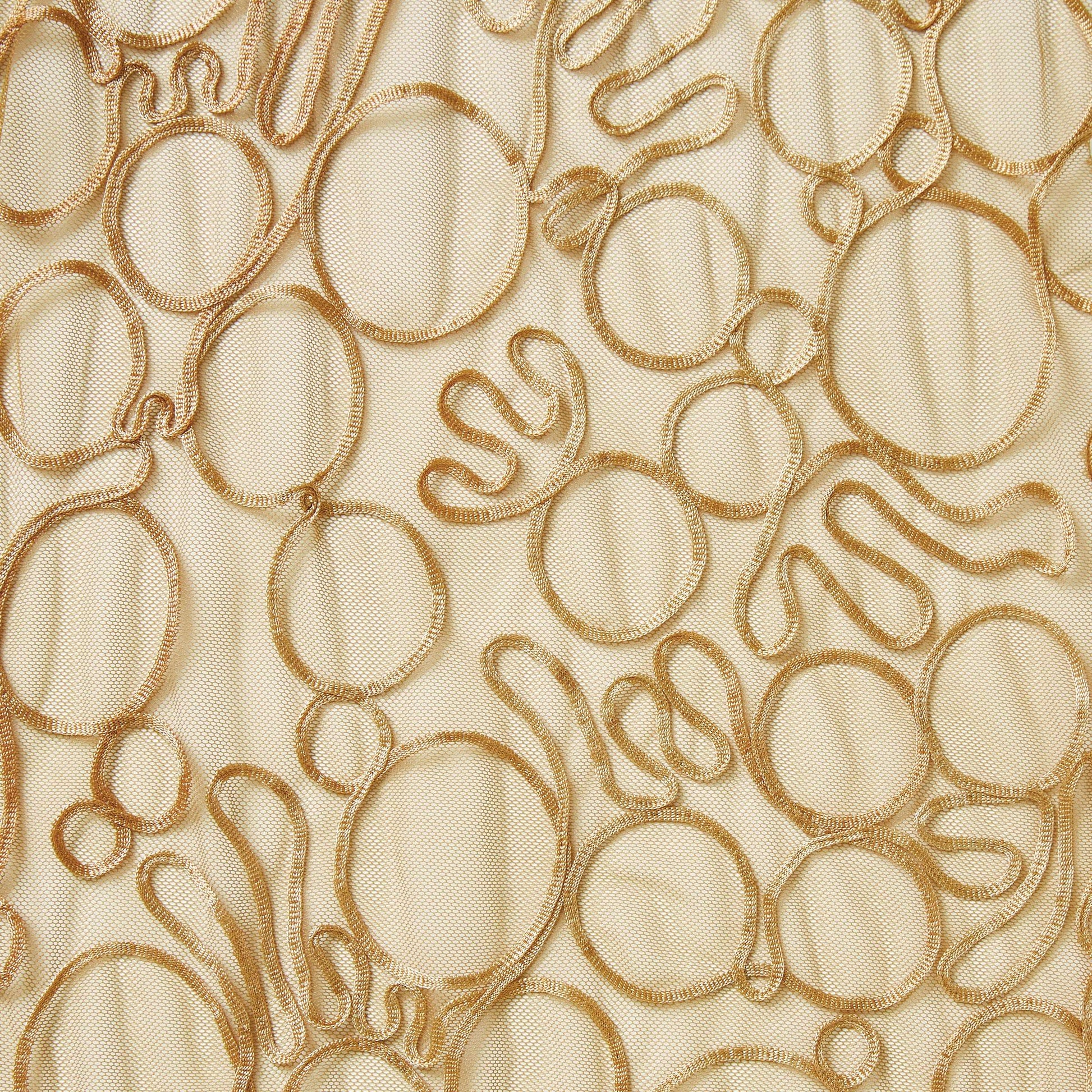roulette showing the tan color version of a polyester and rayon abstract circular Embroidery on fine sheer mesh