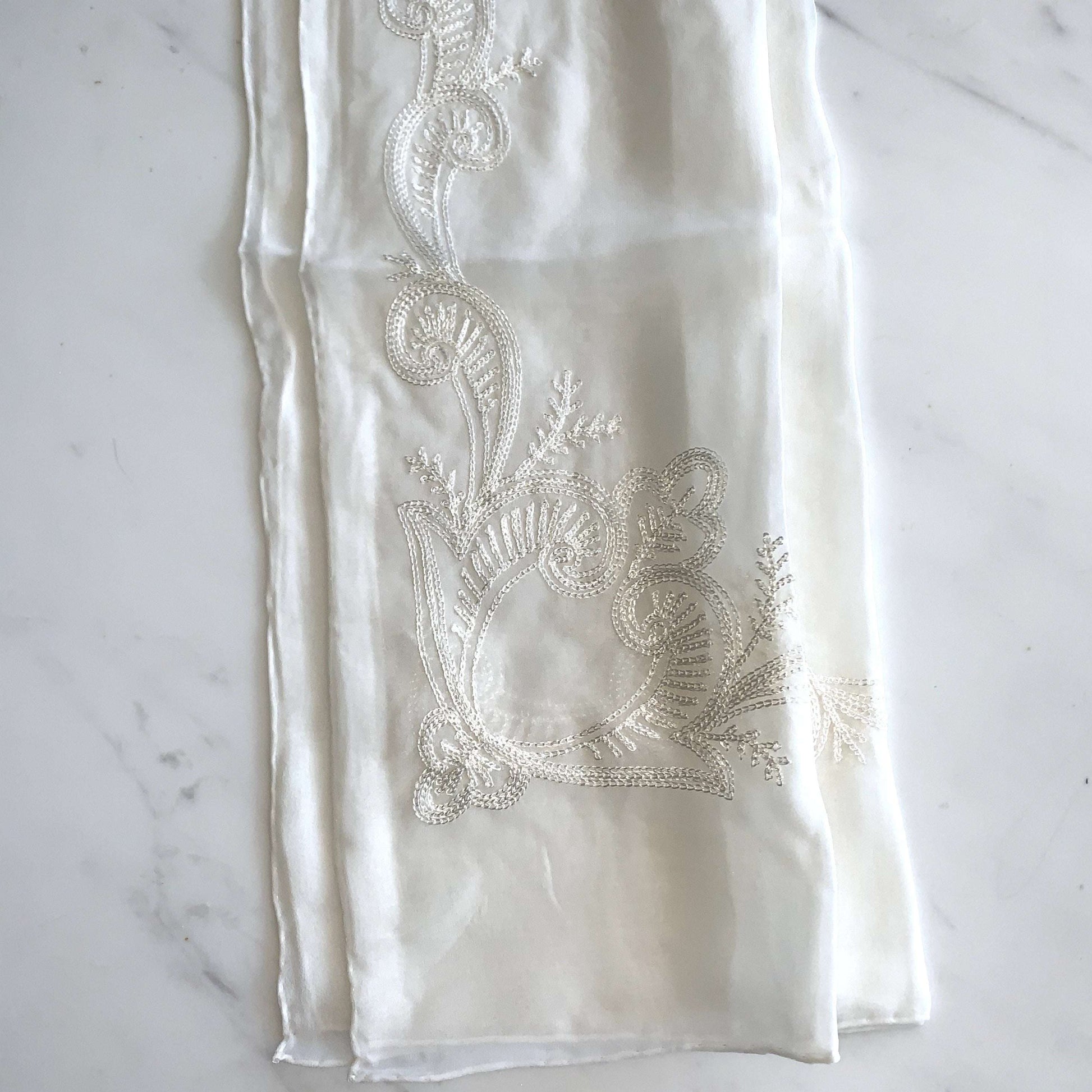 Showing Embroidered Corner Scarf displaying a natural color soft and light weight pure silk scarf embroidered border