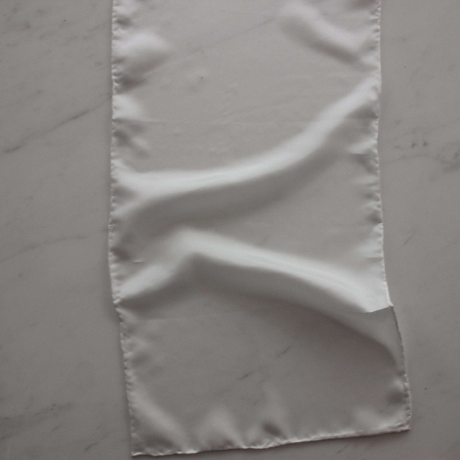 Displaying pajeant scarf featuring a natural colored soft feather weight pure silk 28cm x 160cm with rolled edge and floaty fluid drape