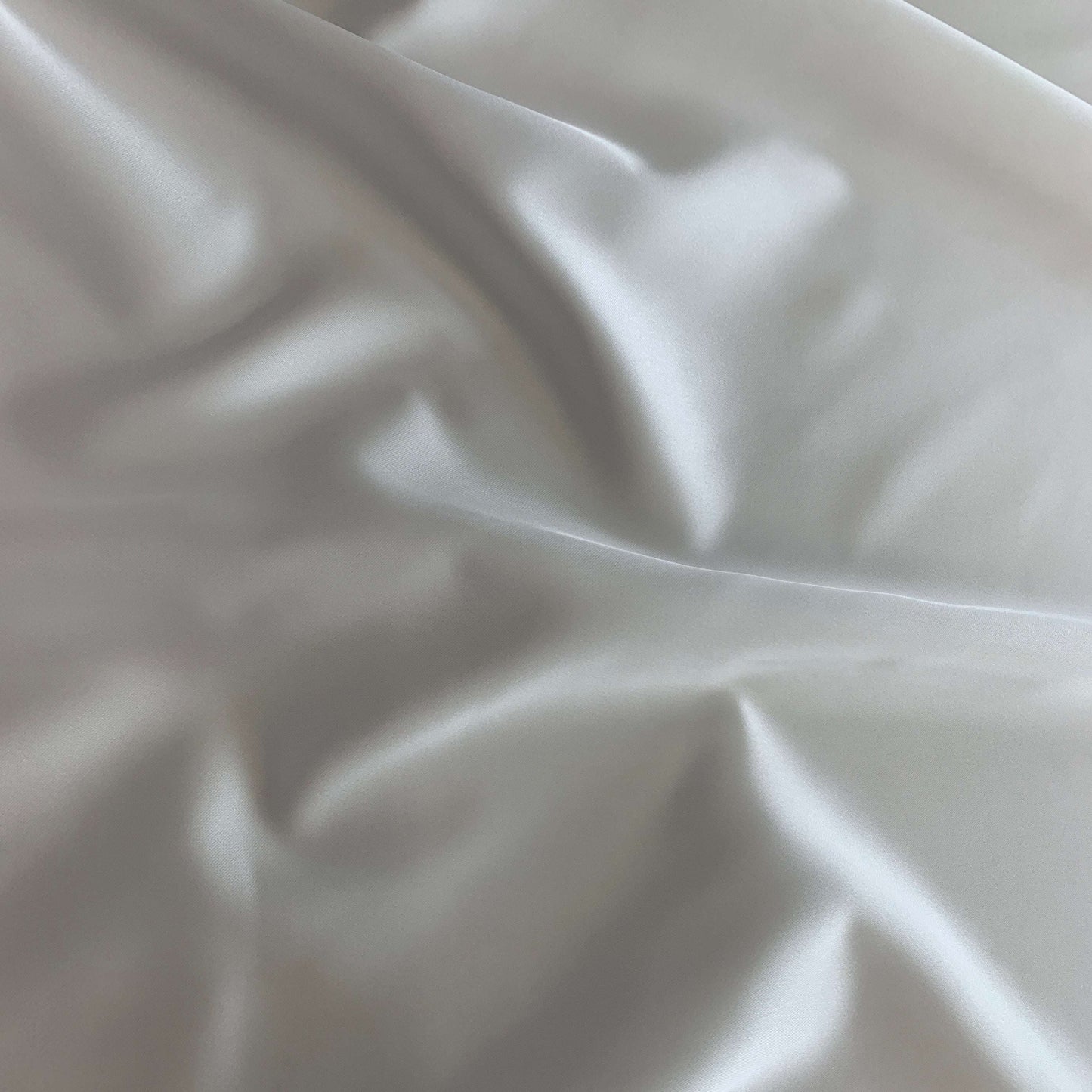 Showing Stella heavy stretch satin a ivory colored polyester Microfiber and Spandex blended fabric