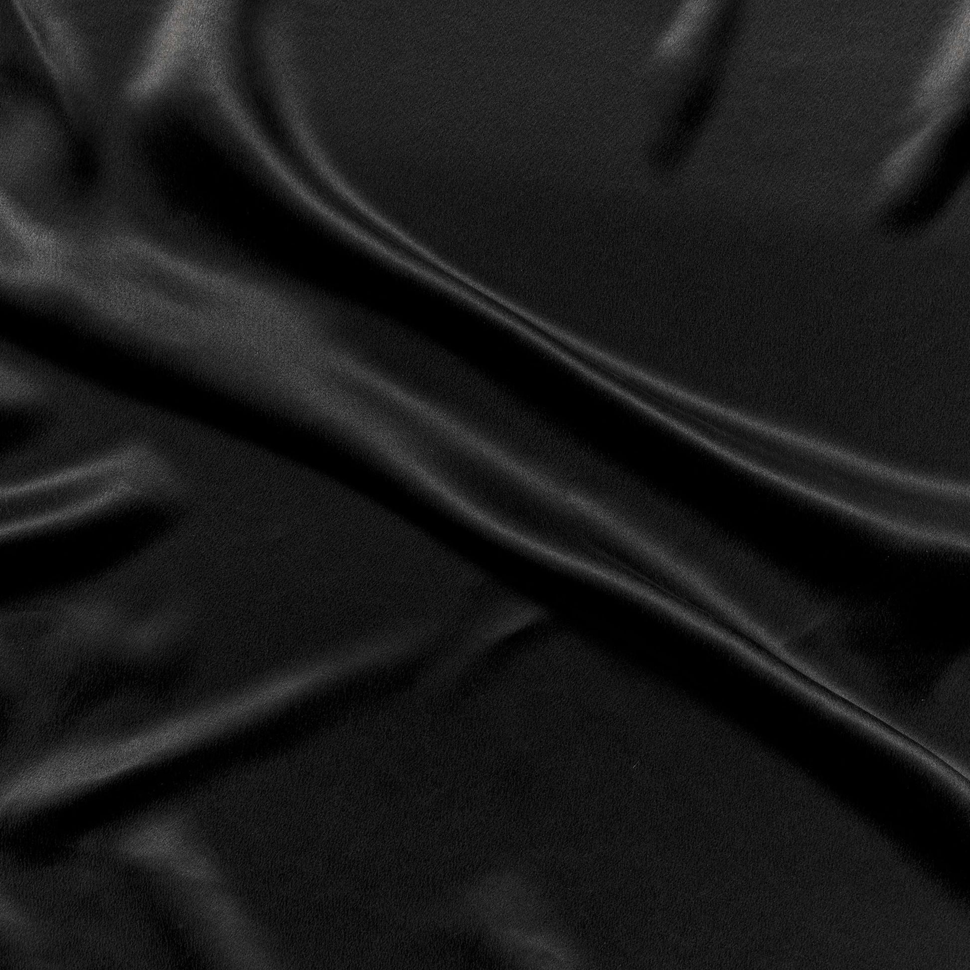 supremo showing the black color version of a soft sand washed delustered pure silk with fluid drape