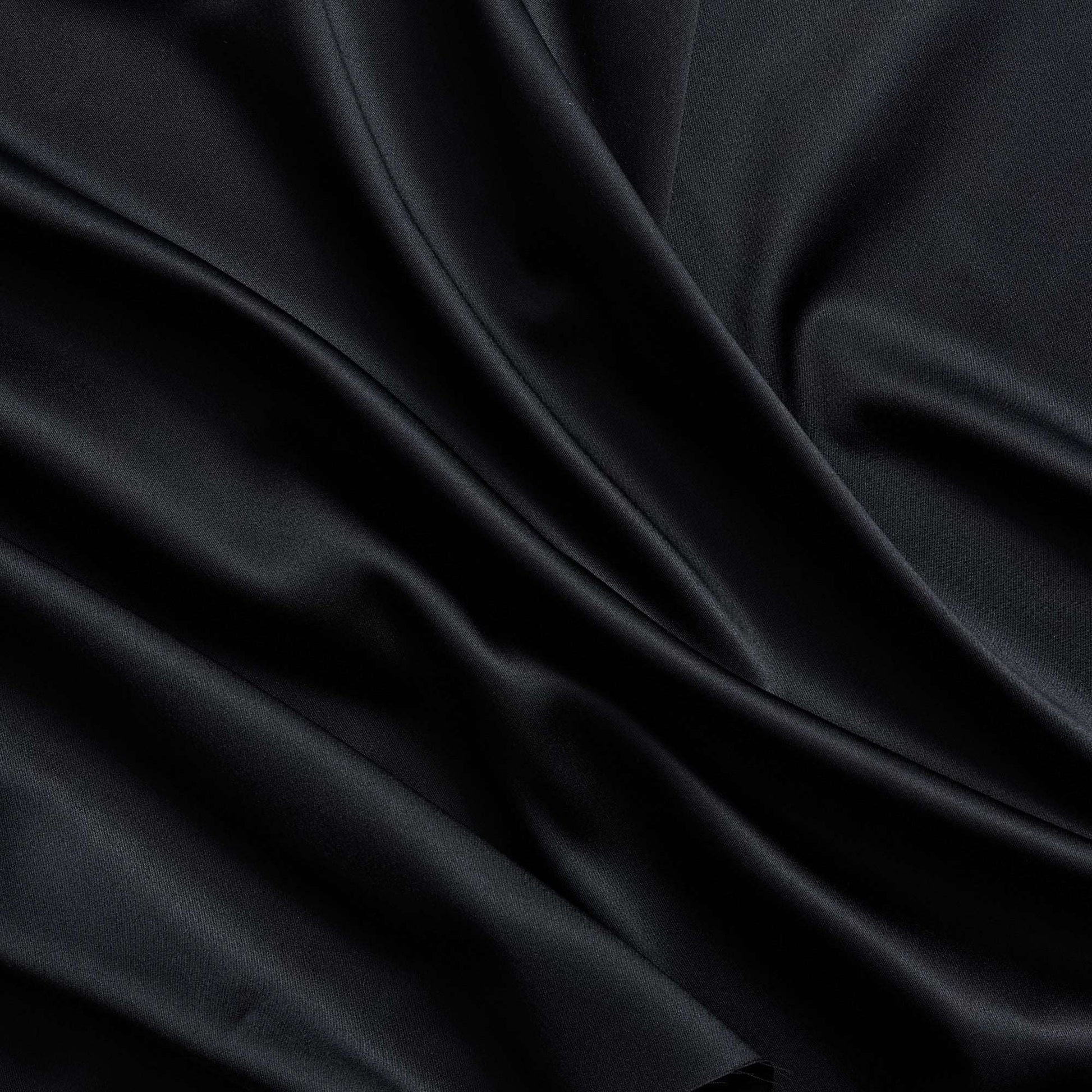 Trump showing the black color version of a stretch duchess satin polyester and lycra blend with a delustered smooth sateen finish and gutsy weight