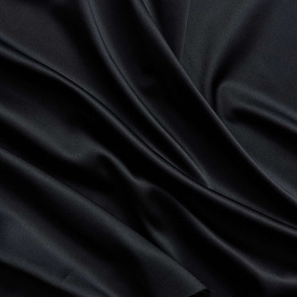 Trump showing the black color version of a stretch duchess satin polyester and lycra blend with a delustered smooth sateen finish and gutsy weight
