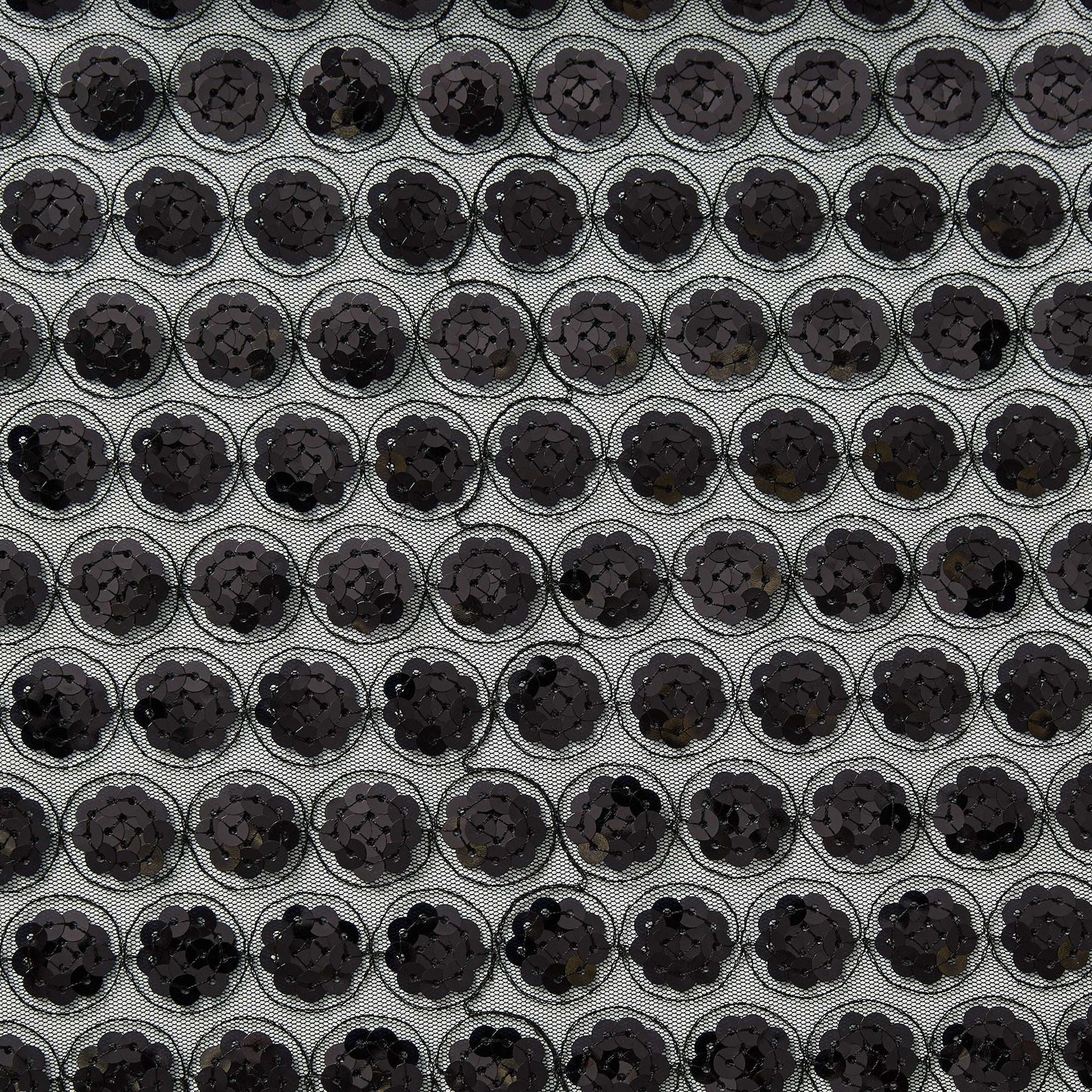 Showing vegas a black colored Sequinned embroidery in regurlar spots on a sheer black polyester mesh  base
