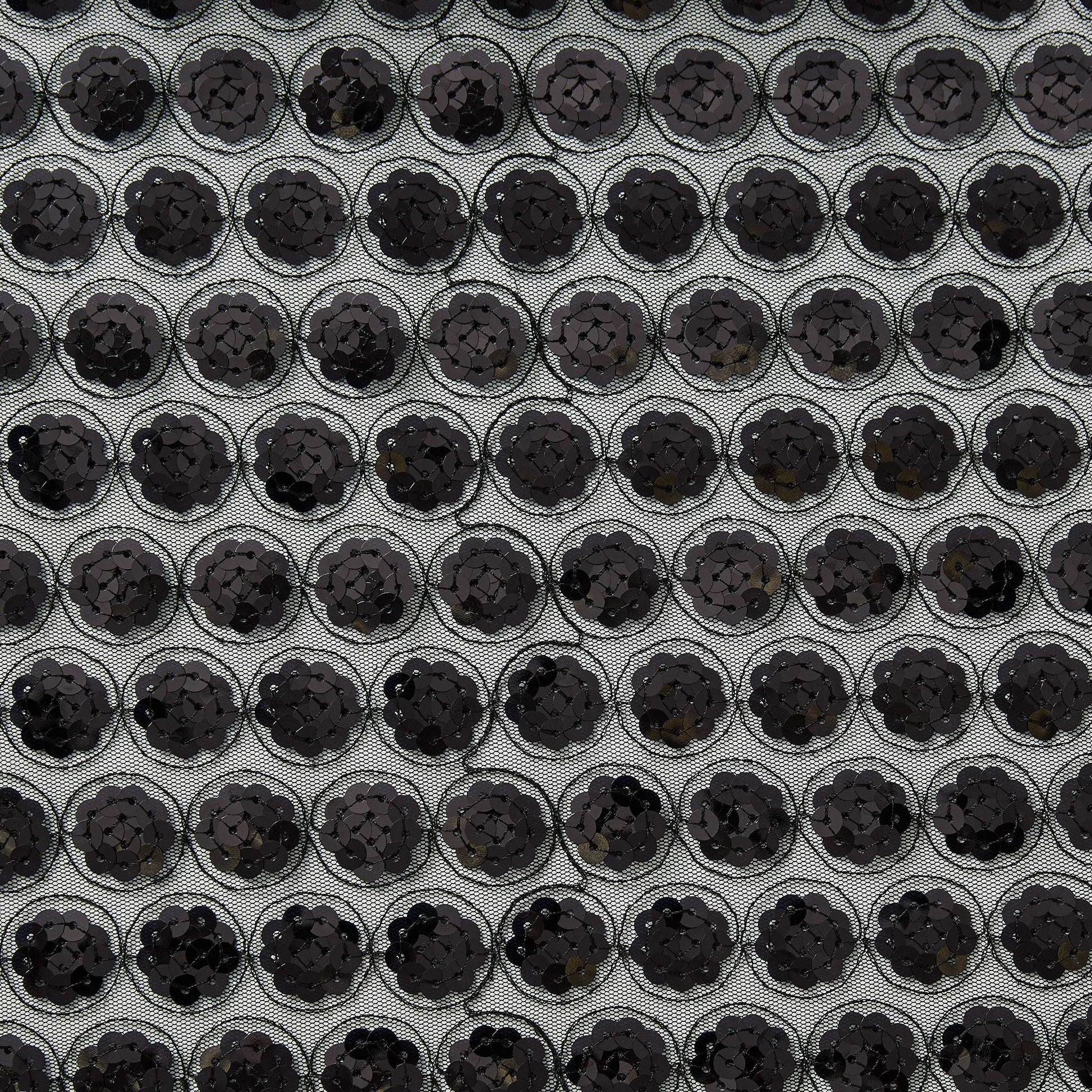 Showing vegas a black colored Sequinned embroidery in regurlar spots on a sheer black polyester mesh  base
