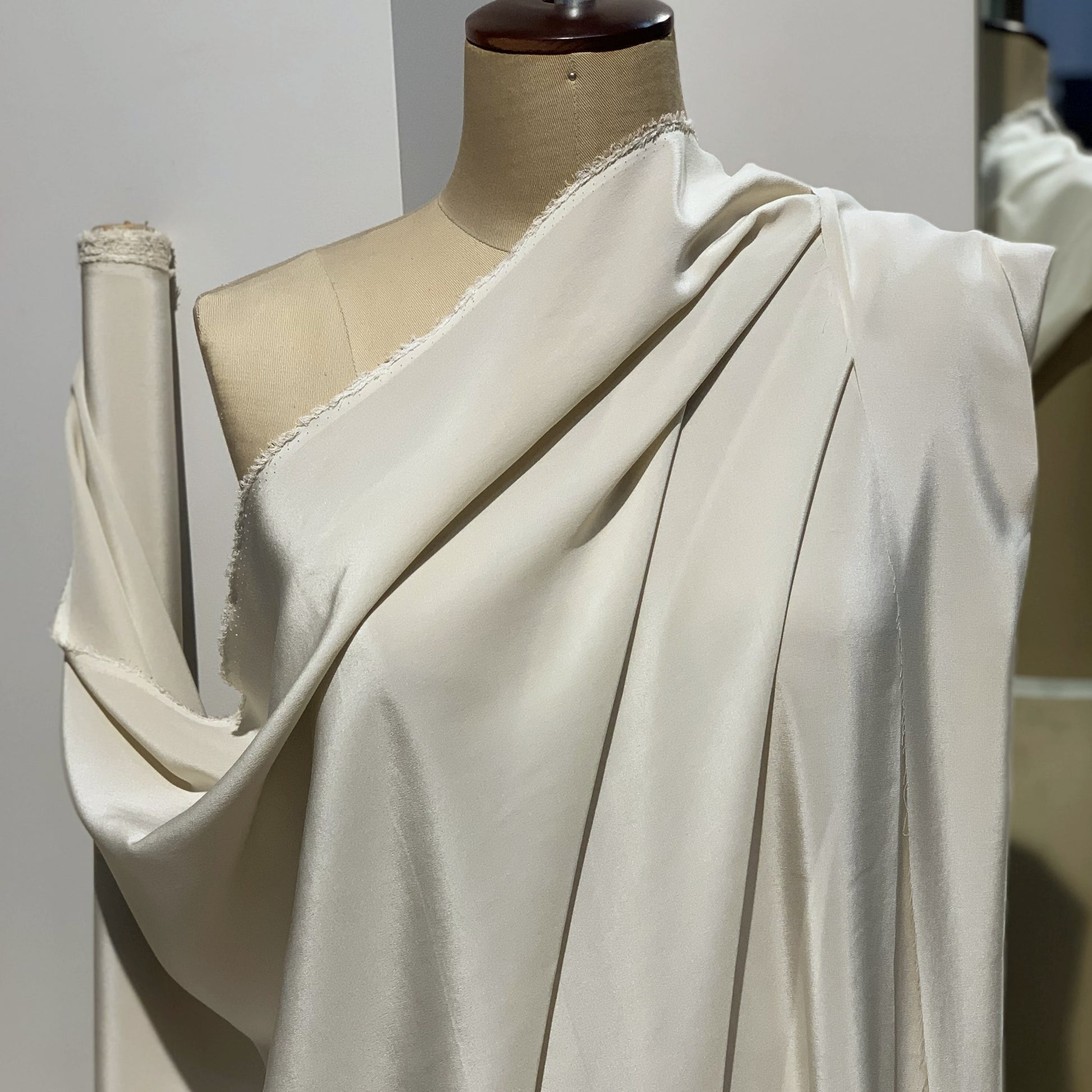 Crepe De Chine showing the draped almond color version of a  Pure mulberry silk with fluid drape and a matte face and cool handle