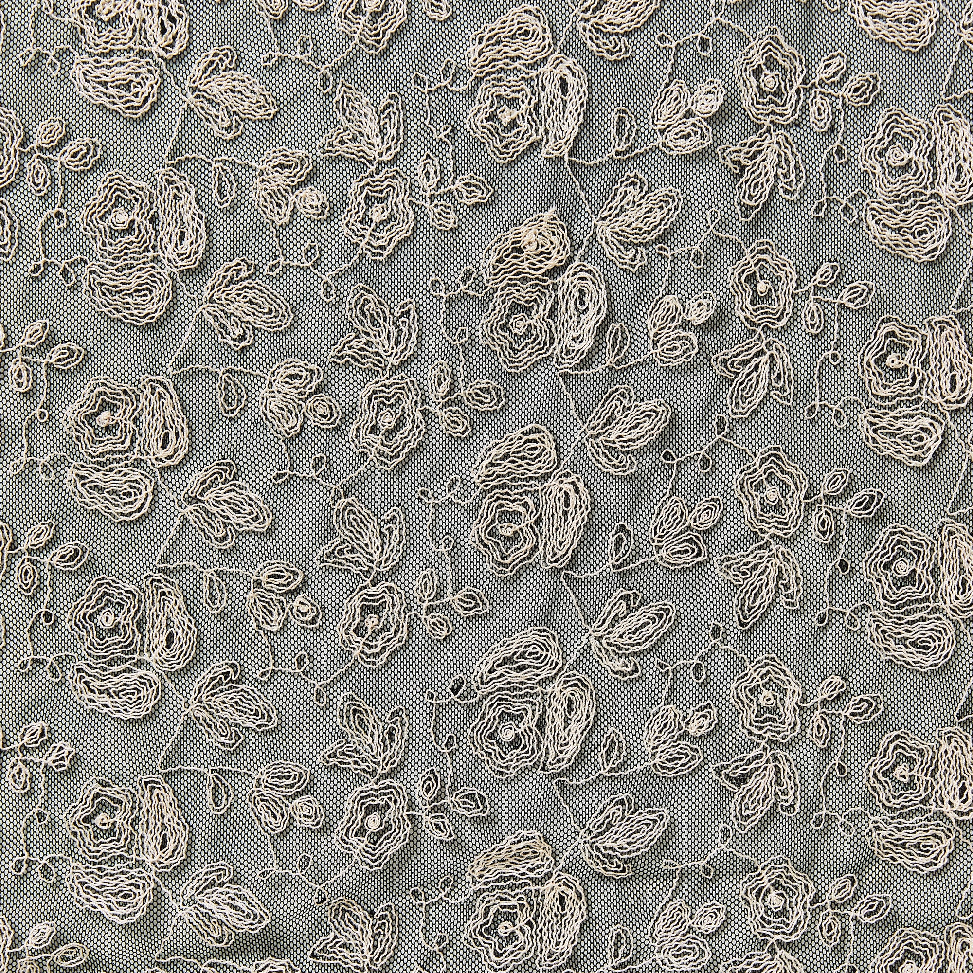 claudia displaying an ivory color version of a rayon Floral Roses design embroidered on a black nylon mesh