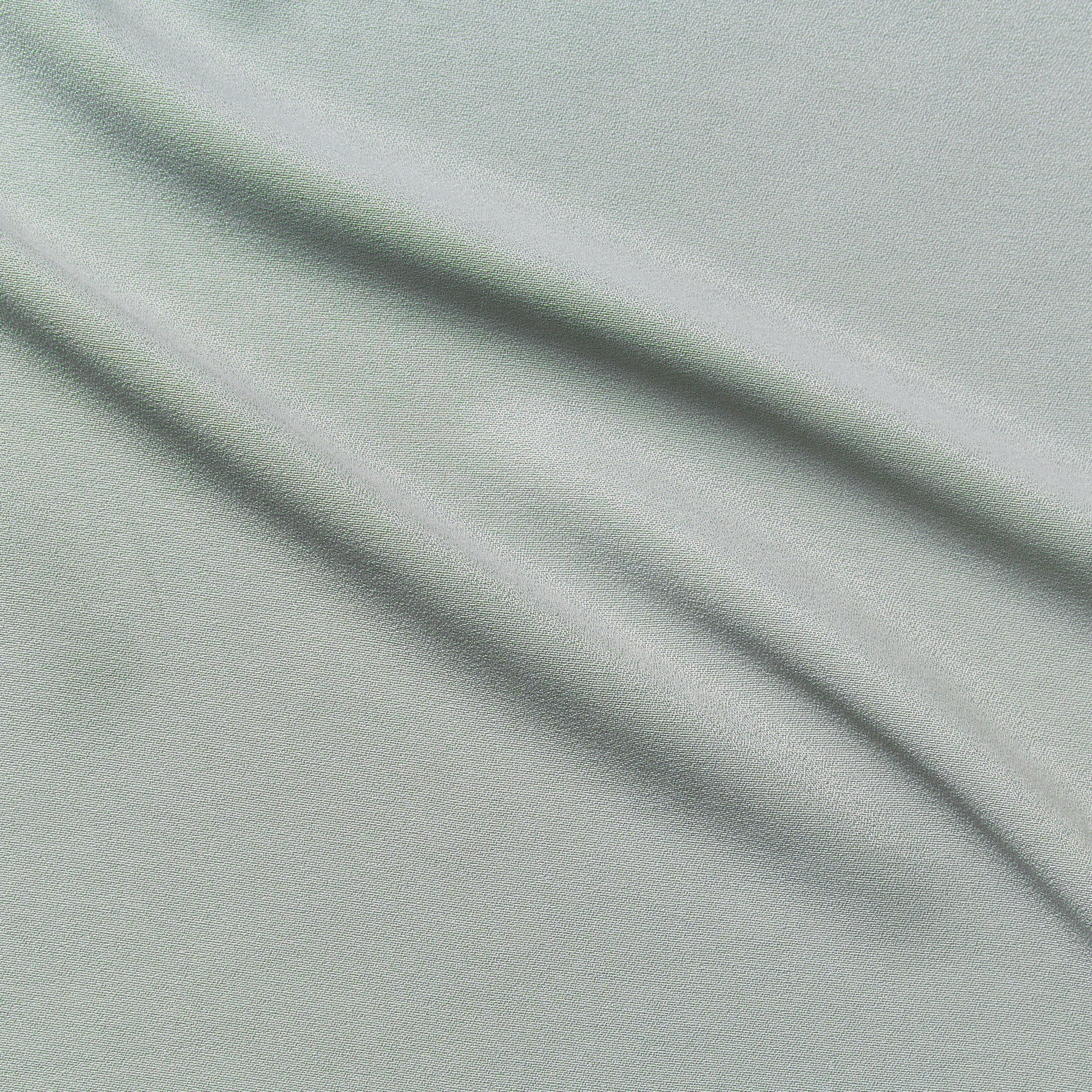 columbia displaying the mint color version of a textured face rayon and acetate blend with good drape